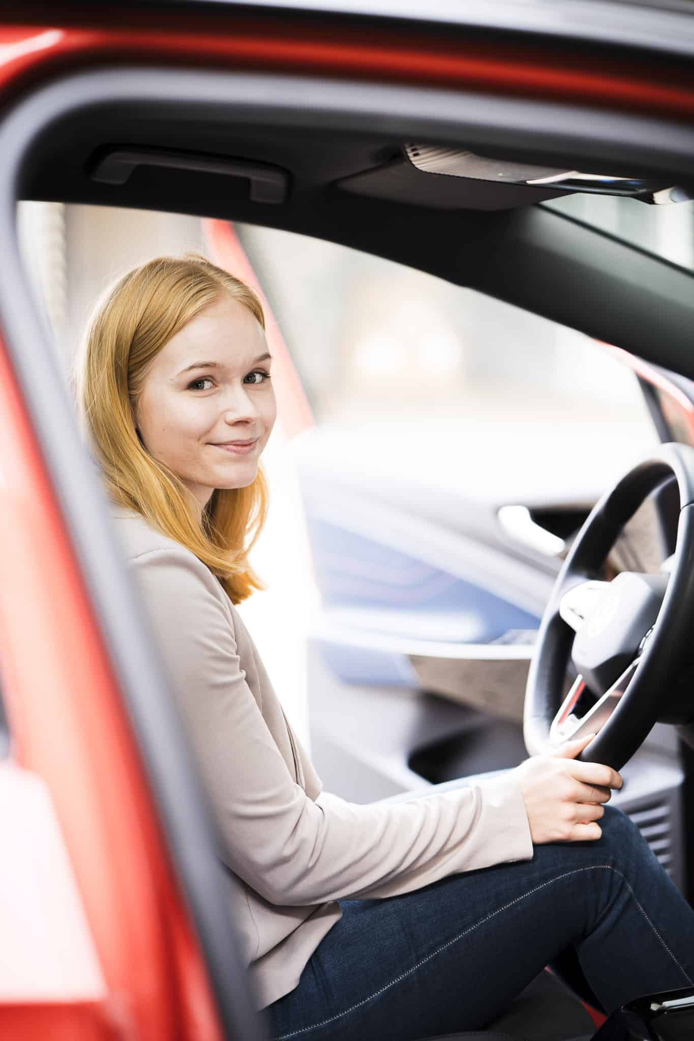 Zufriedene Mitarbeiterin in ihrem Job-E-Auto