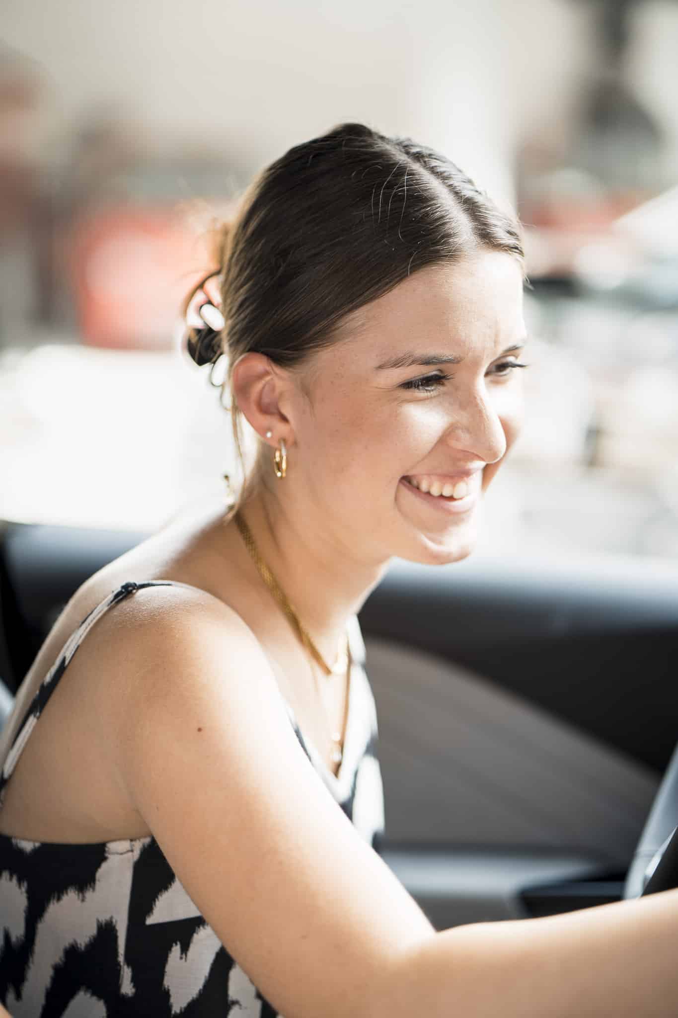 Zufriedene Mitarbeiterin in ihrem Job-E-Auto